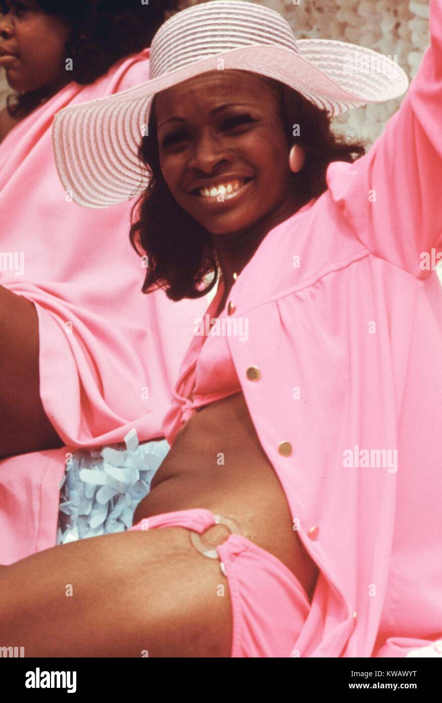 A woman in a pink outfit and sunhat waves from a float during the annual Bud Billiken Day parade in Chicago, Illinois, August, 1973. Image courtesy National Archives. Stock Photo