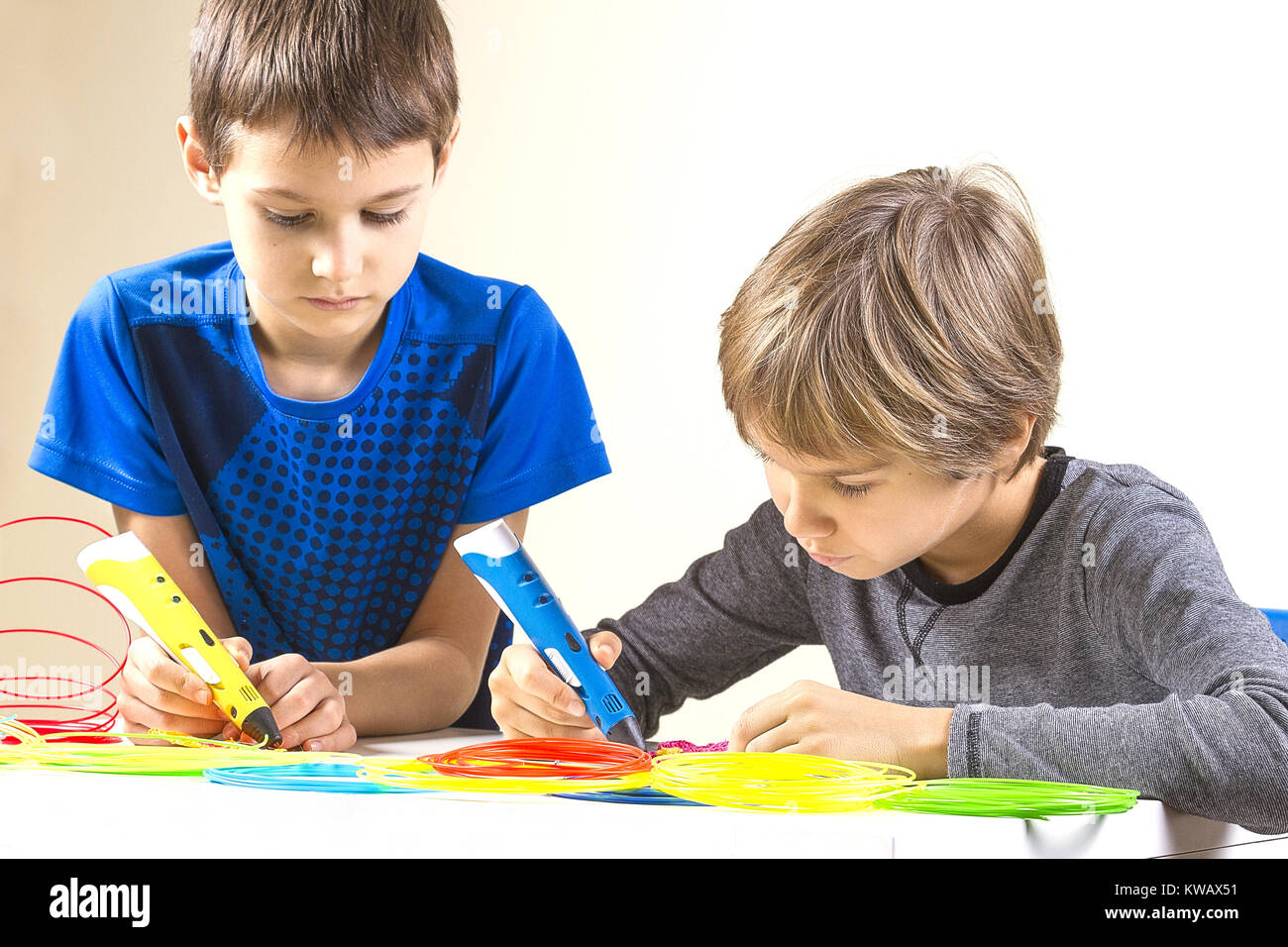 Two boys creating with 3d printing pen Stock Photo - Alamy