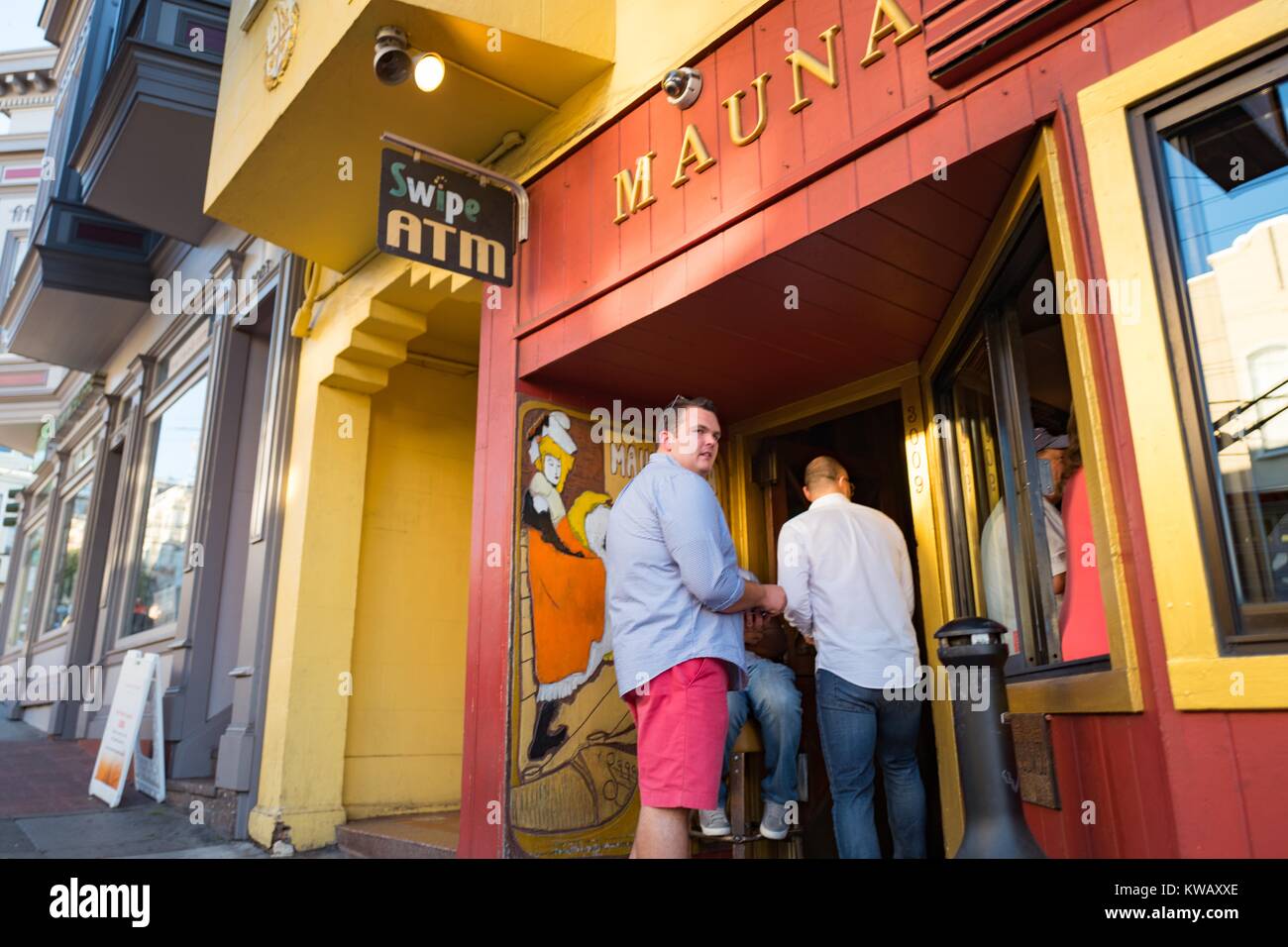 A doorman is checking the IDs of two men entering the Mauna Loa Club in San Francisco, California, October 8, 2016. Stock Photo