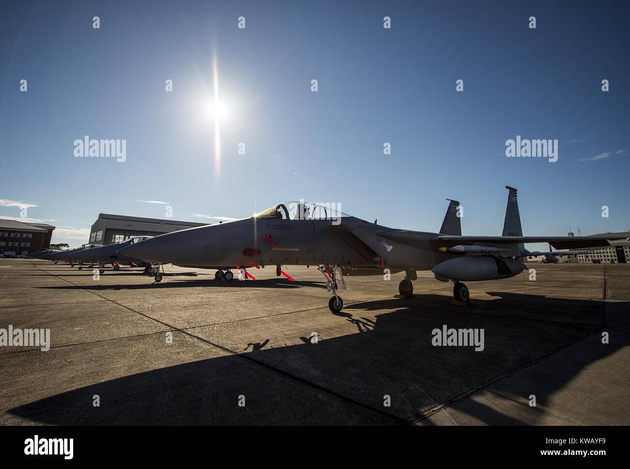 Clear skies and bright sun shines down on a row of 125th Fighter Wing F-15s from Jacksonville Fla. on the Eglin Air Force Base flightline Oct. 7, October 7, 2016. The Air National Guard unit sent 15 aircraft to ride out Hurricane Matthew here. The Marine Fighter Attack Squadron-501 sent 10 F-35Bs from South Carolina to the base for sheltering as well. The 96th Aircraft Maintenance Squadron's F-15 unit and the Navy's Strike Fighter Squadron 101 provided support to the transient aircraft. (U.S. Air Force photo/Samuel King Jr.). Stock Photo