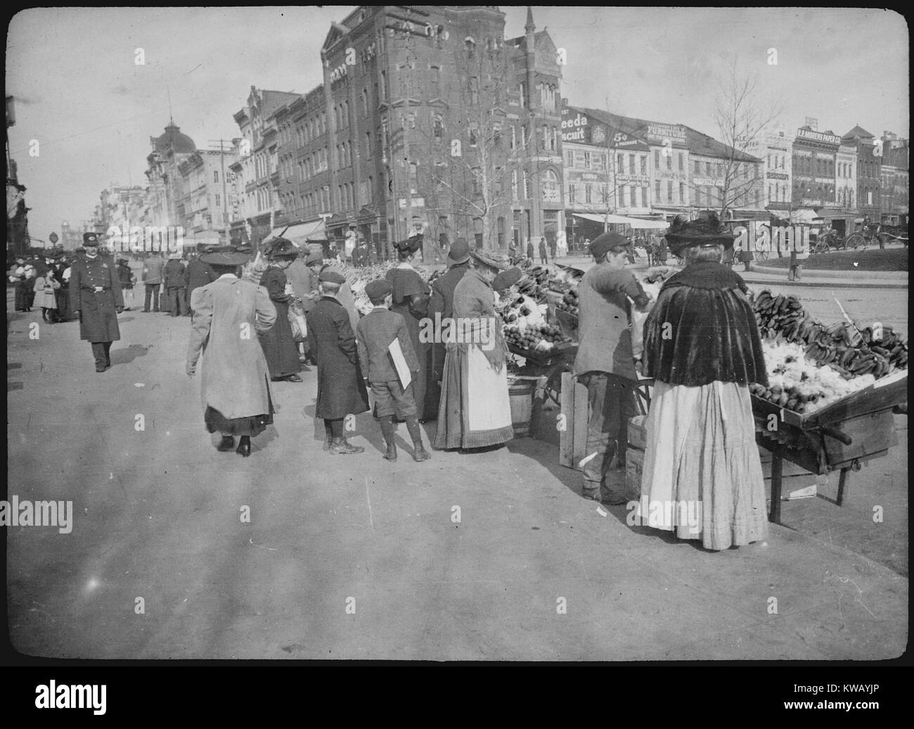 Patrons browse through an outdoor food market on 7th Street at Pennsylvania Avenue in Washington, D.C, 1900. Stock Photo