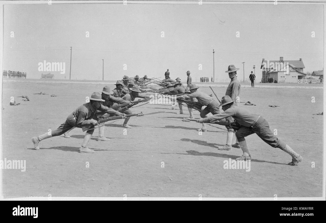 US military recruits bend while practicing a bayonet routine at Camp Bowie, Forth Worth, Texas, 1918. Image courtesy National Archives. Stock Photo