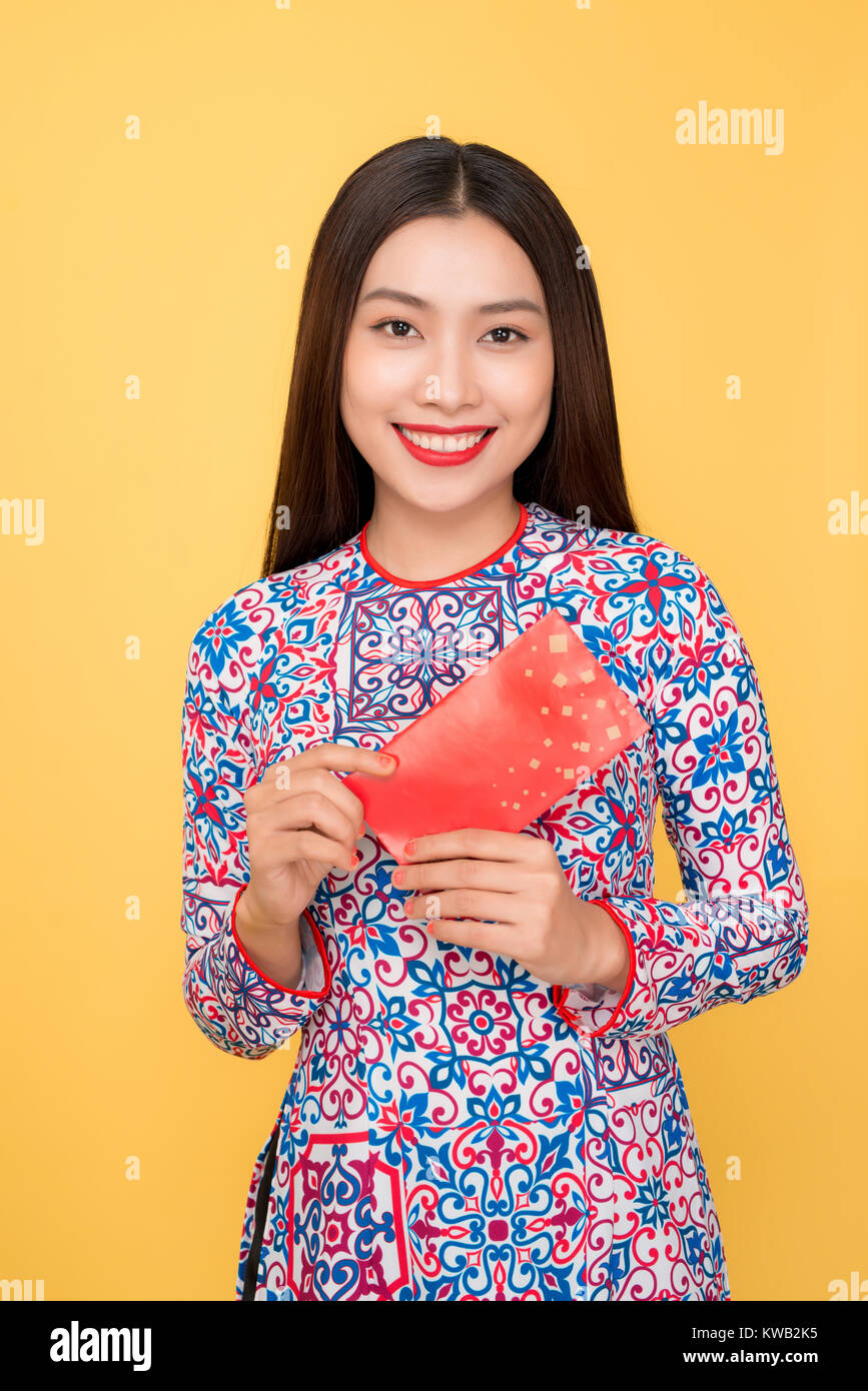 Vietnamese woman traditional festival costume Ao Dai, holding red money