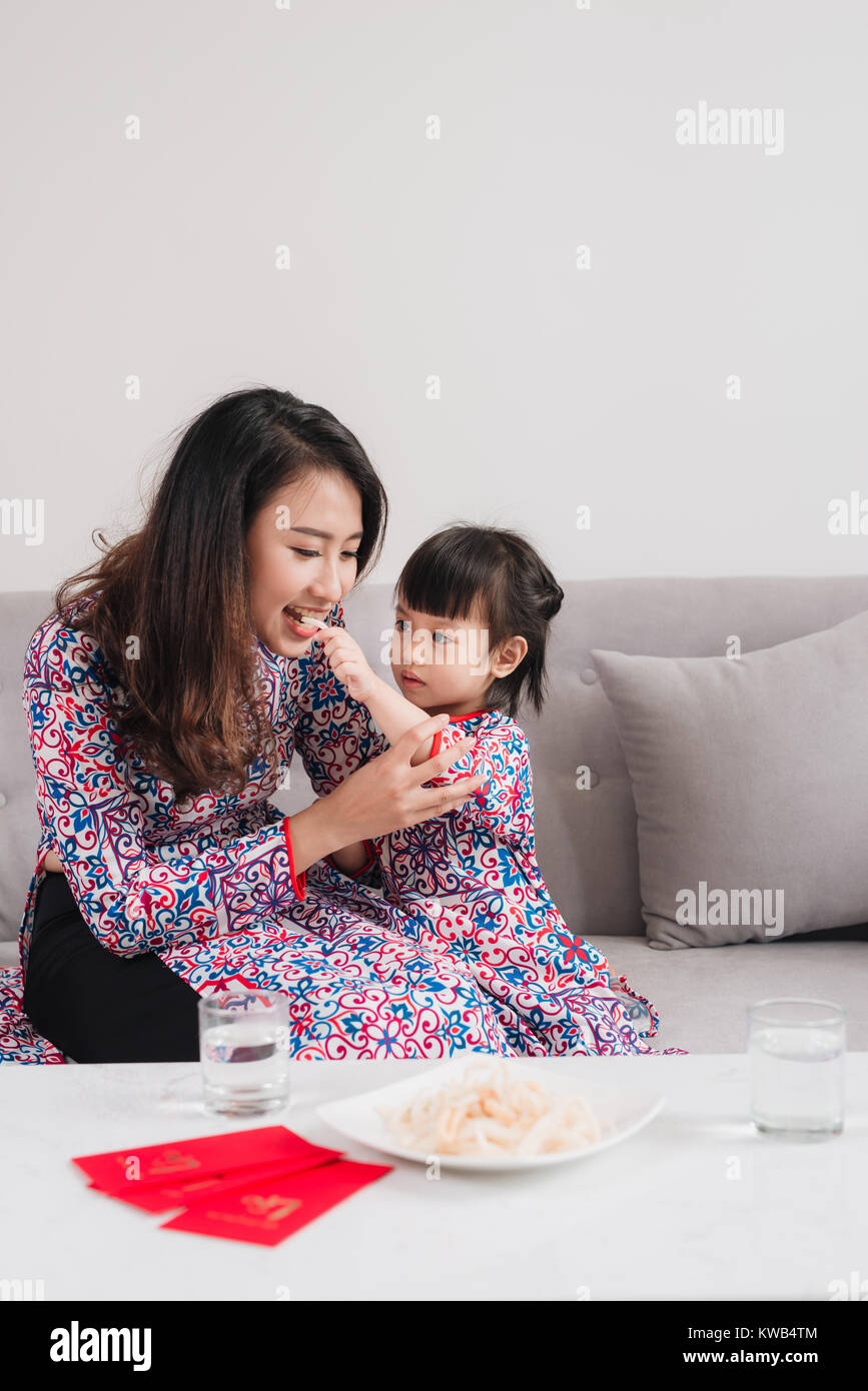 Vietnamese mother and daughter celebrate new year at home. Tet Holiday. Stock Photo
