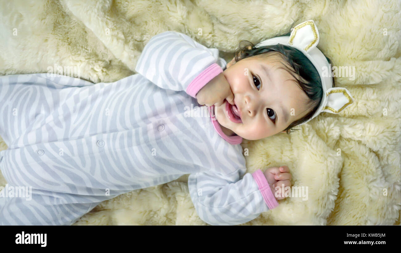 Asian cute baby girl lying on the bed Stock Photo
