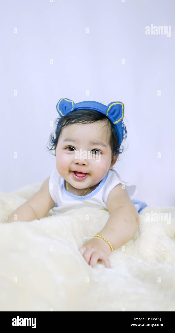 Asian Smiling baby girl crawling in bedroom Stock Photo