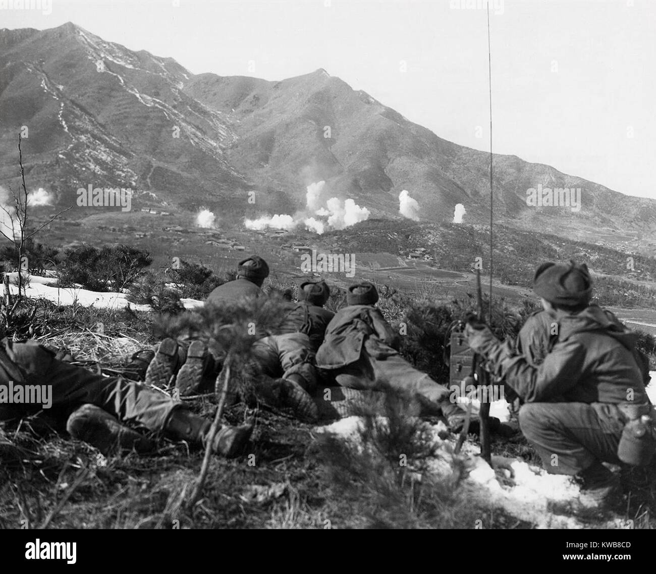 U.S. Soldiers outlook for movement as UN forces drop white phosphorous on a Communist held area. Feb. 1, 1951. Korean War, 1950-53. (BSLOC 2014 11 103) Stock Photo