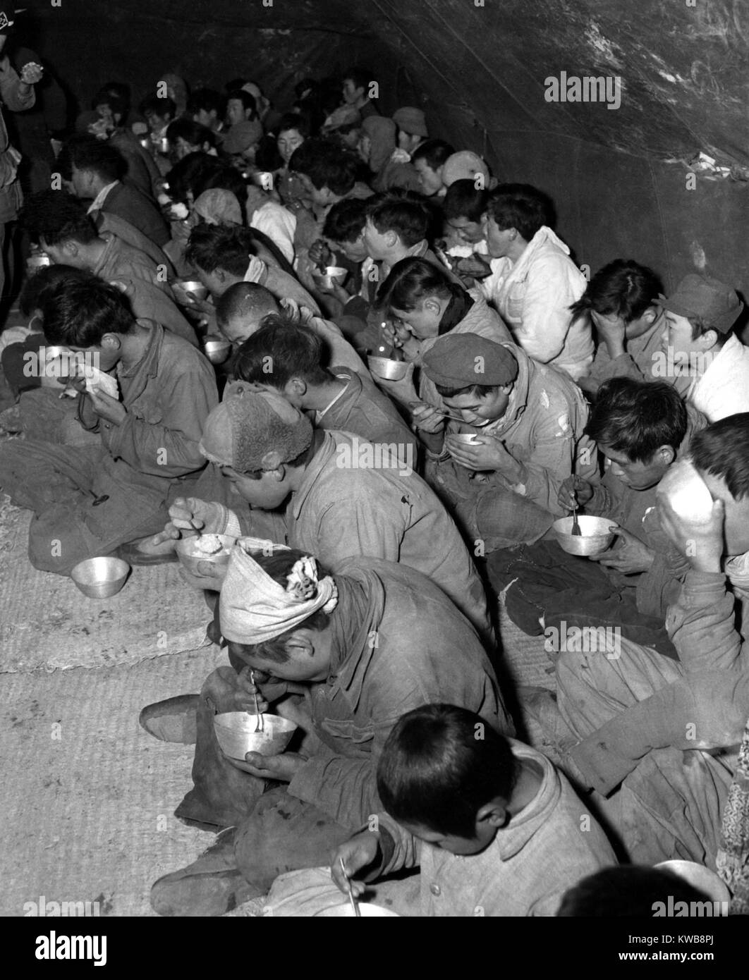 Communist soldiers are fed in the POW stockade, Kurije, Korea. They were captured and brought down from Mt. Chirisan, by soldiers of the ROK (Republic of Korea) Capitol Division. Dec. 12, 1951. Korean War, 1950-53. (BSLOC 2014 11 172) Stock Photo