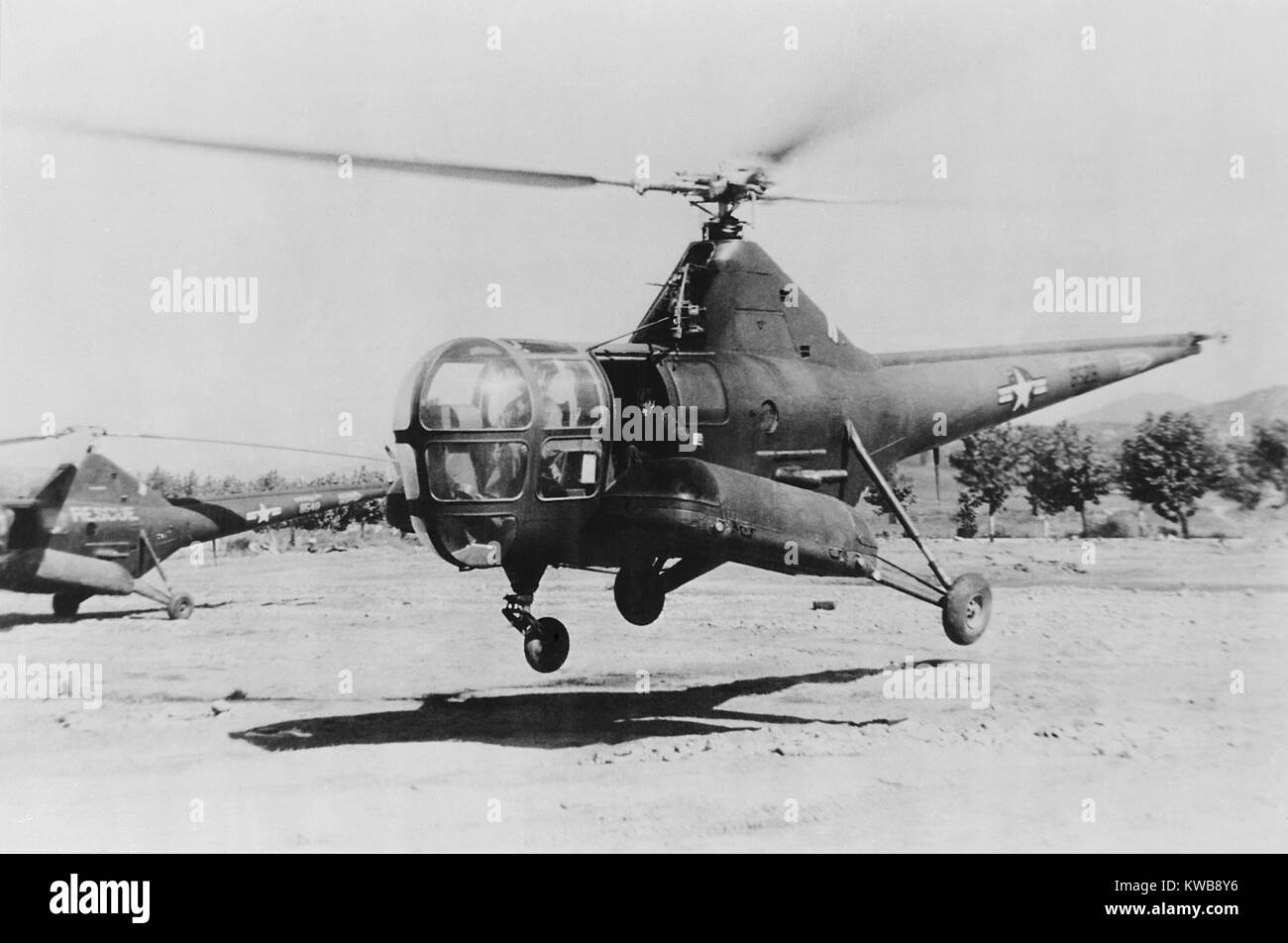 Medic gave a blood transfusion to wounded soldier during the flight from the front lines. The casualty was enclosed in an outboard metal capsule attached to the side of an Air Rescue helicopter. Korean War, 1950-53. (BSLOC 2014 11 197) Stock Photo