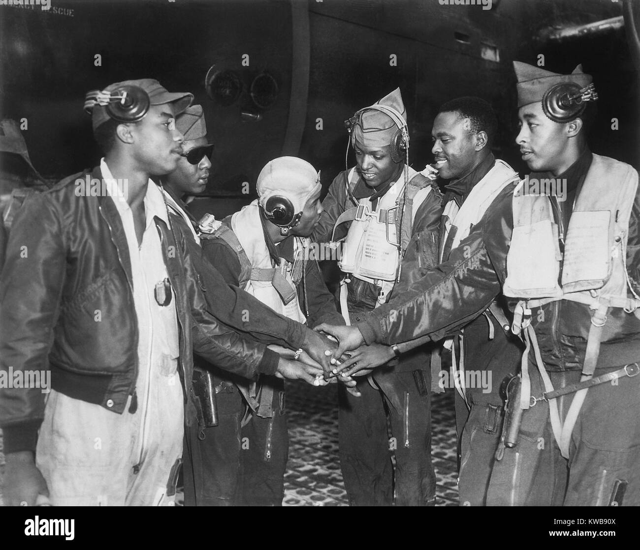 Six African American Air Force gunners join hands. They are part of 17th Bomb Wing night interdiction teams in Korea. Air interdiction attacked ground targets not close to friendly ground forces. Korean War, 1950-53. (BSLOC 2014 11 209) Stock Photo