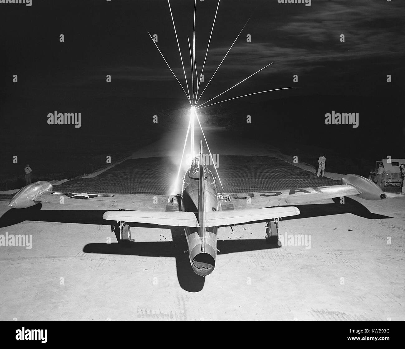 F-84 Thunderjet firing .50 caliber tracer bullets as maintenance men ...