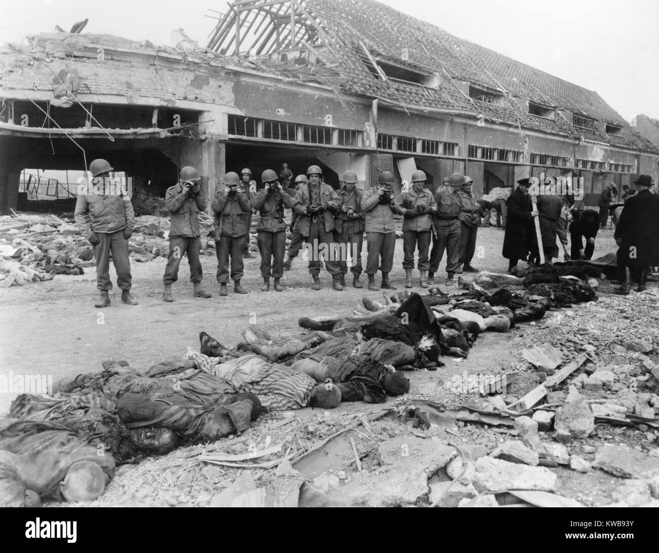 U.S. soldiers photographing of a row of dead inmates, Nordhausen Concentration Camp, April 1945. U.S Army extensively documented the war crimes in the concentration and death camps of Germany and Austria. World War 2. (BSLOC 2014 10 179) Stock Photo