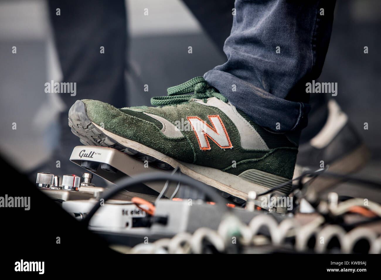 A musician and guitarist wears New Balance sneakers on stage at a live  concert. Denmark, 02/07 2014 Stock Photo - Alamy