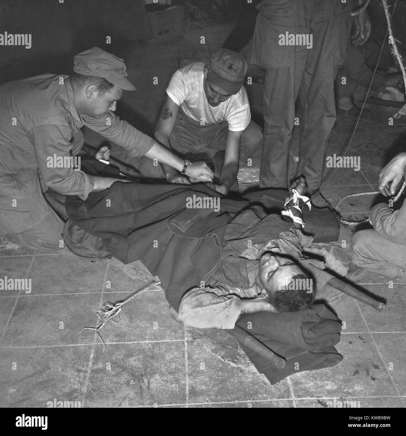 Navy corpsman gives a wounded U.S. Marine blood plasma at 'Yellow Beach' Inchon, Korea. Sept. 19, 1950. After stabilization, the wounded were transferred to hospital ships. Korean War, 1950-53. (BSLOC 2014 11 47) Stock Photo