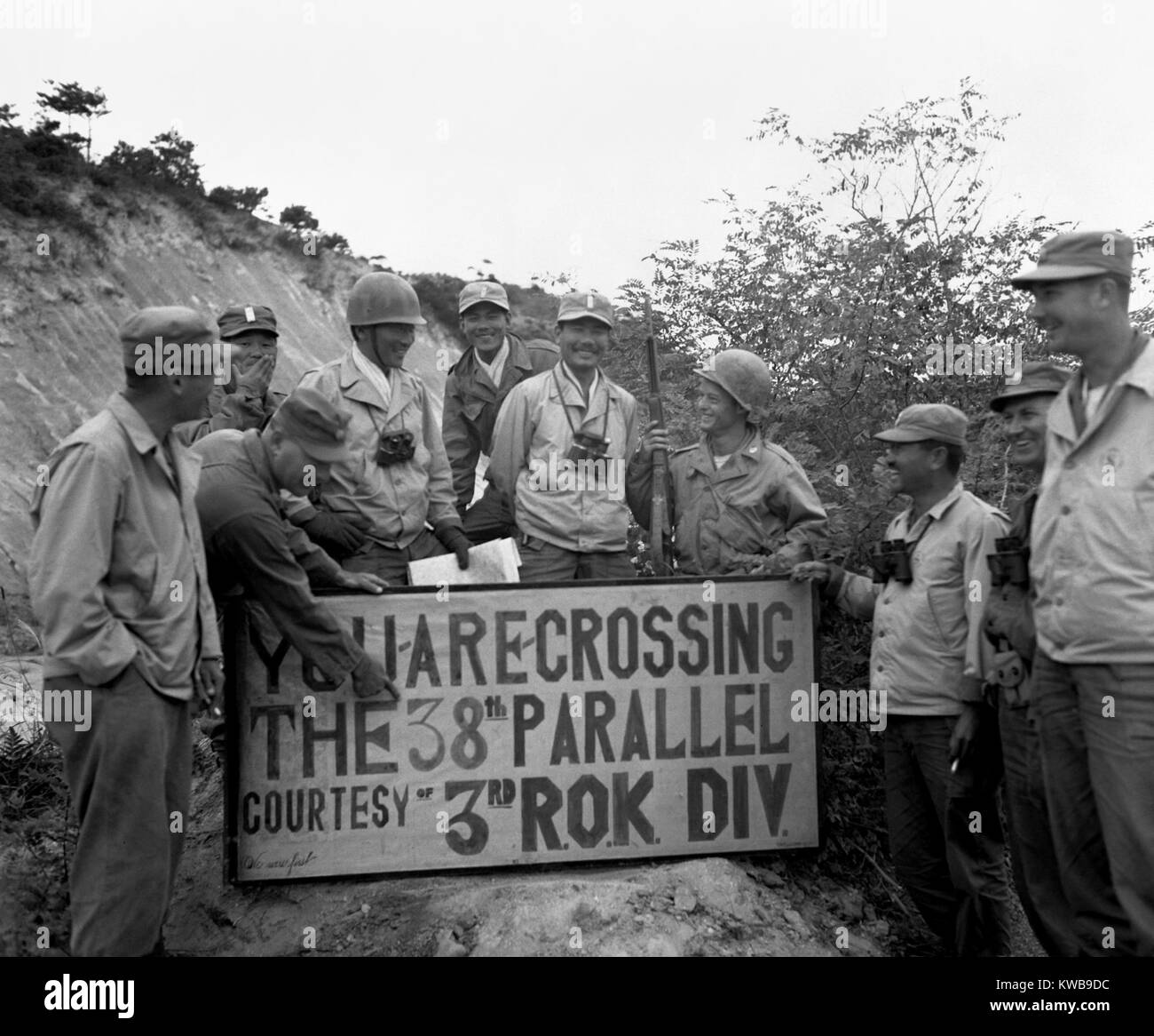 First UN troops to cross the 38th Parallel hold a sign posting ceremony. The 3rd ROK (Republic of Korea) Division made the historic crossing, in Korea. ROK soldiers pose with their U.S. Military advisors. Oct. 1, 1950. Korean War, 1950-53. (BSLOC 2014 11 63) Stock Photo