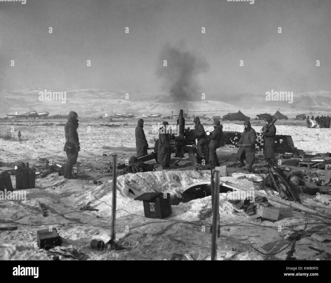 Marine 105mm howitzers defend Hagaru-ri airstrip from Chinese army as planes evacuate wounded. Guns fire right over airfield into nearby hills as main body of 1st Marine Division returns from Chosin Reservoir area from Yudam-Ni. Nov. 28 -Dec. 3, 1950. Korean War, 1950-53. (BSLOC 2014 11 82) Stock Photo