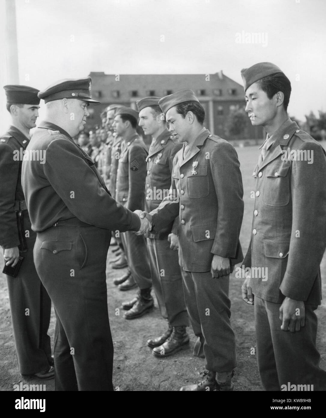 Pfc. William Wada, a Japanese American soldier is awarded the Bronze Star Medal for heroism. He stands beside another Japanese American to be honored by Gen. Ralph M. Immel. June 1, 1945. European Theater, World War 2. (BSLOC 2014 10 47) Stock Photo