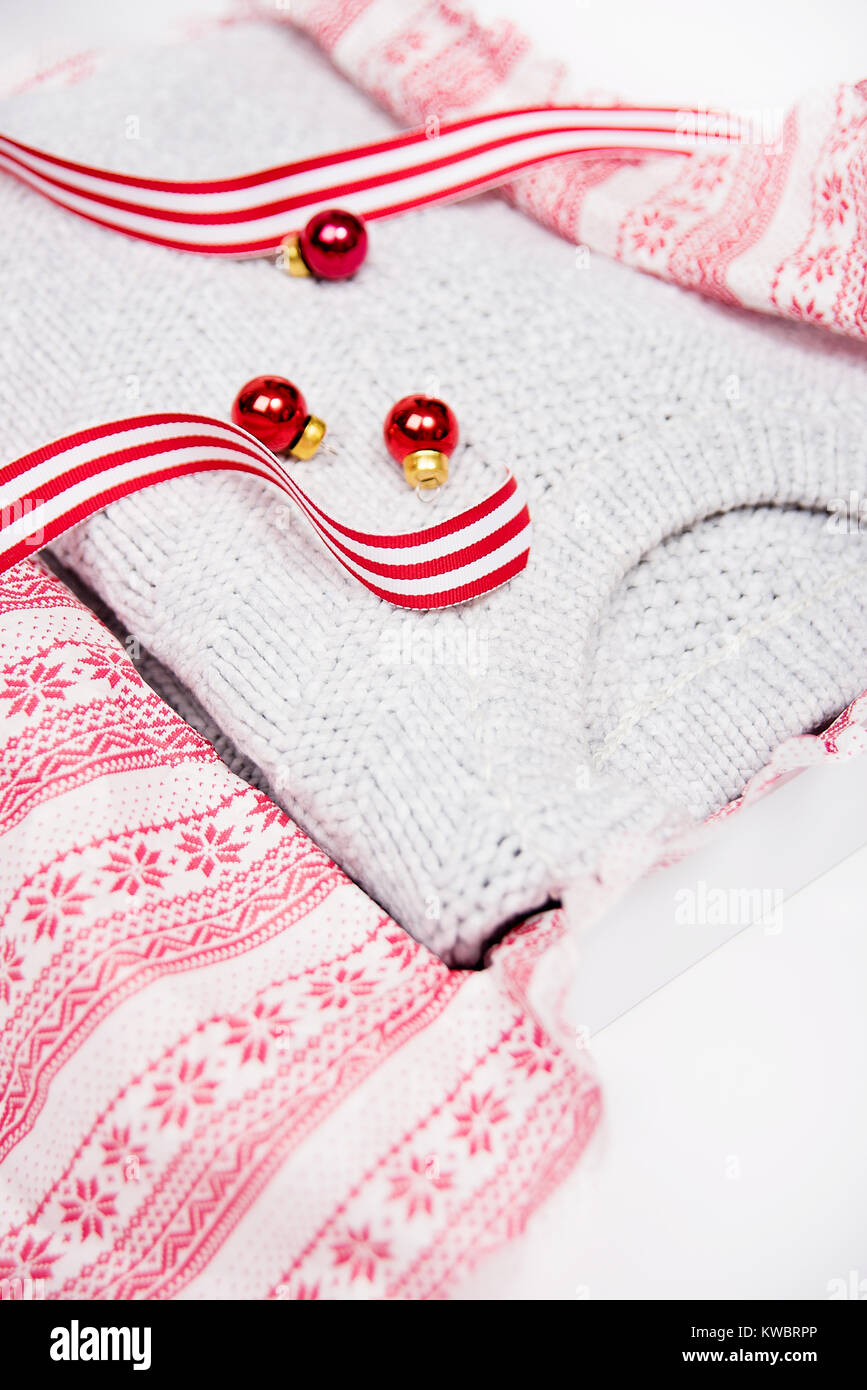 Light Gray Sweater Being Gift Wrapped for Christmas in Box and White and Red Striped Ribbon Stock Photo