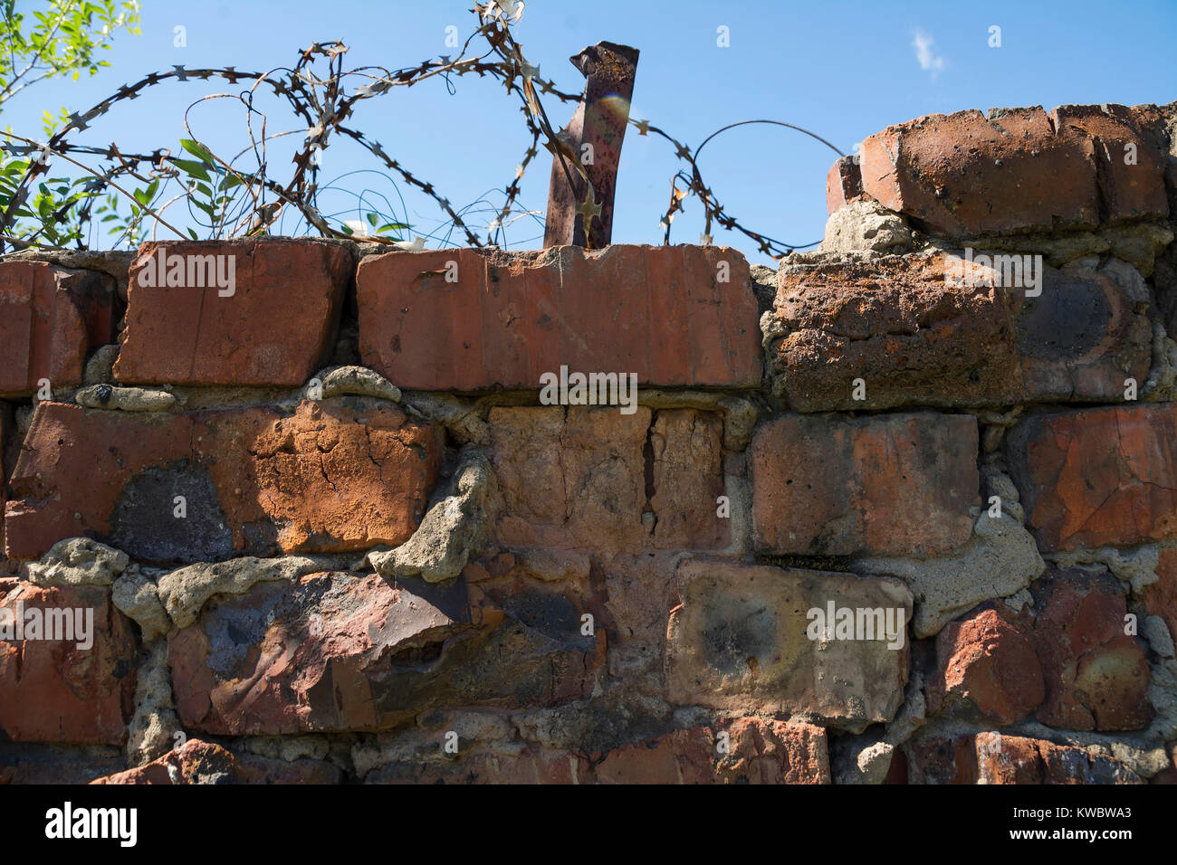 Part of brick wall with barbed wire Stock Photo - Alamy
