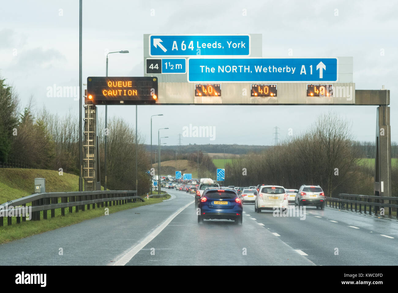 UK motorway gantry sign with warning and speed restriction where M1 motorway and A1M merge heading north Stock Photo