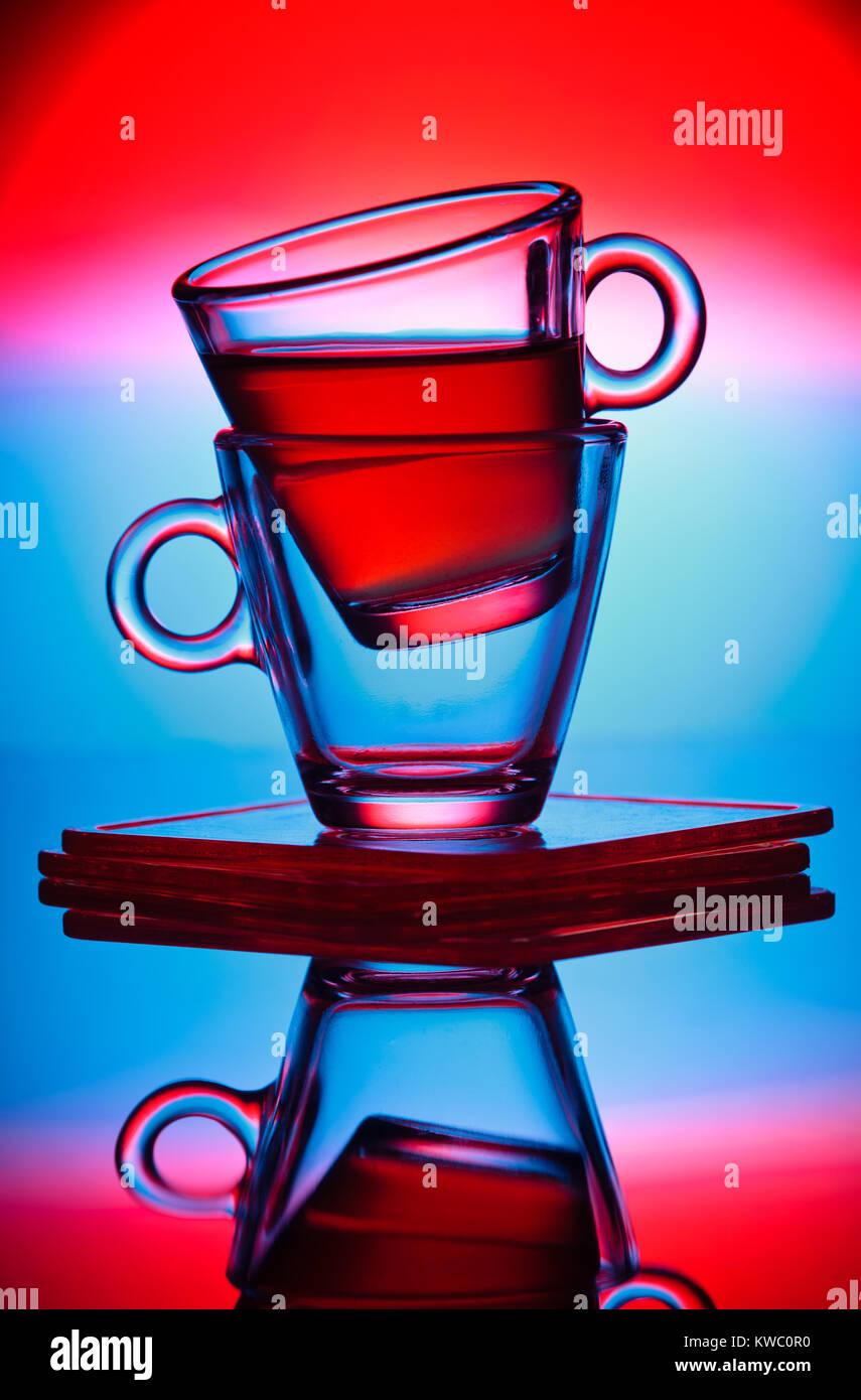 Transparent cups on colorful surreal background Stock Photo - Alamy