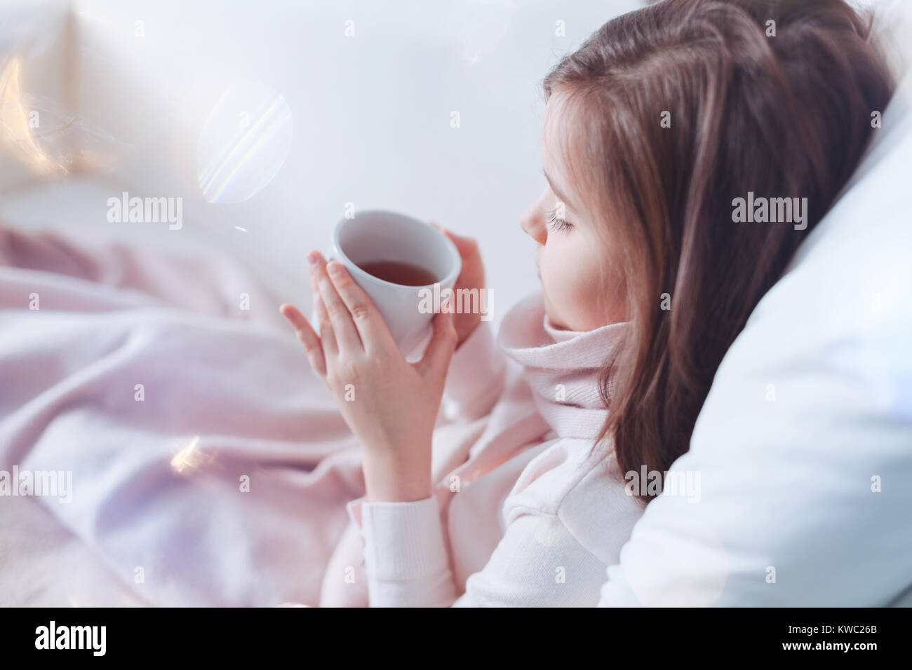 Profile photo of sick child that holding cup with tea Stock Photo