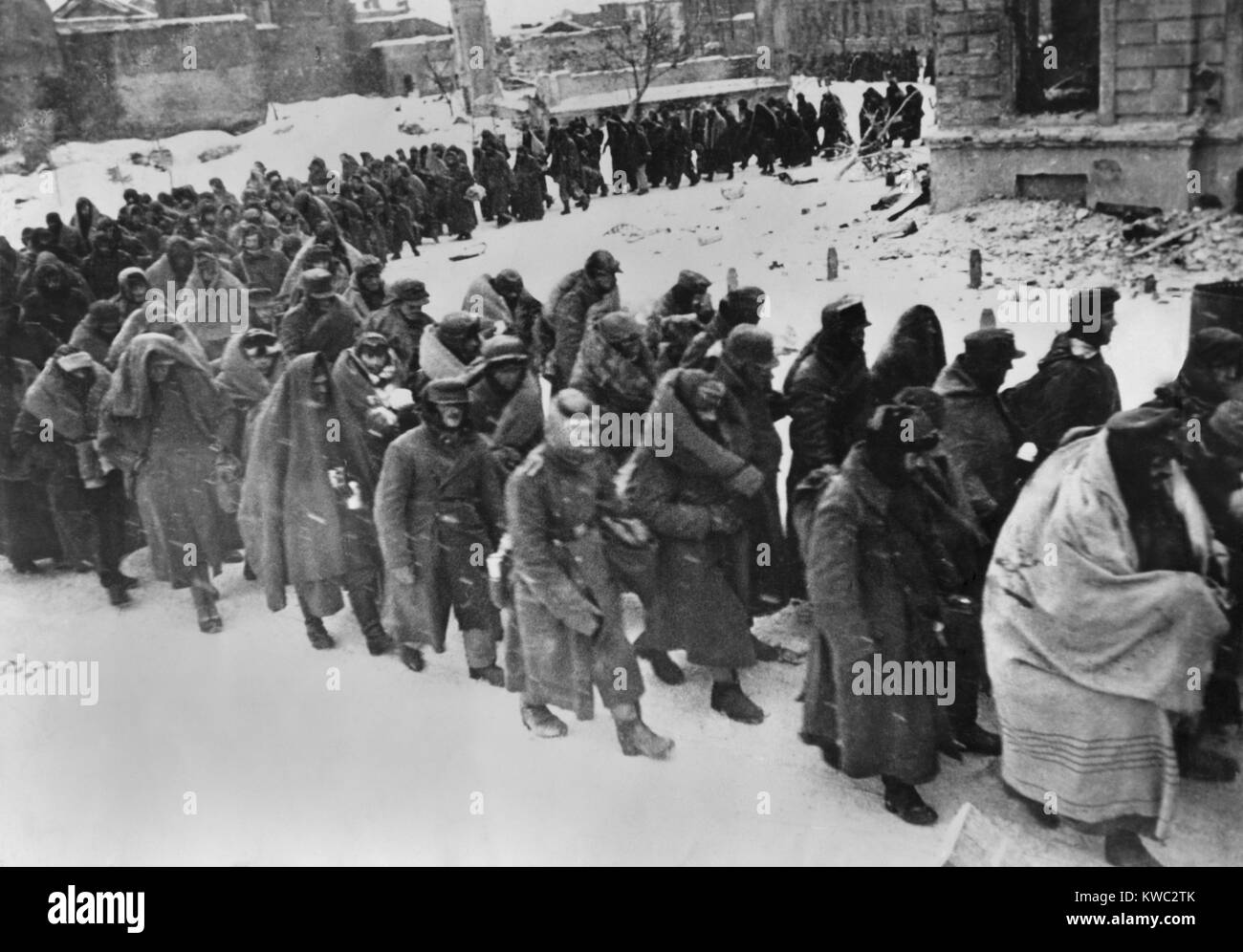 German prisoners march through the snowy streets of battered Stalingrad in Jan.-Feb. 1943. Wrapped in blankets or anything else to protect from the winter weather, they are the remnants of the destroyed German 6th Army. Of the 107,800 soldiers taken prisoner, only 6000 were known to survive their captivity. World War 2 (BSLOC 2015 13 111) Stock Photo