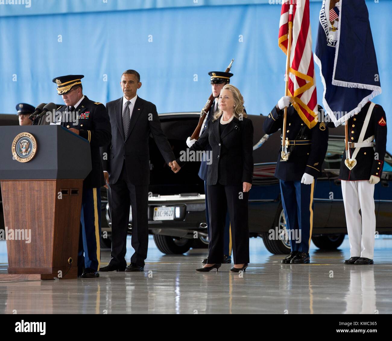 President Barack Obama holds hands with Sec. of State Hillary Rodham Clinton at Andrews Field, MD. On Sept. 14, 2012 they witnessed the transfer of remains ceremony of four Americans: J. Christopher Stevens, U.S. Ambassador to Libya; Sean Smith, Information Management Officer; and Security Personnel Glen Doherty and Tyrone Woods. All were killed in the attack on the U.S. Consulate in Benghazi, Libya. (BSLOC 2015 13 231) Stock Photo