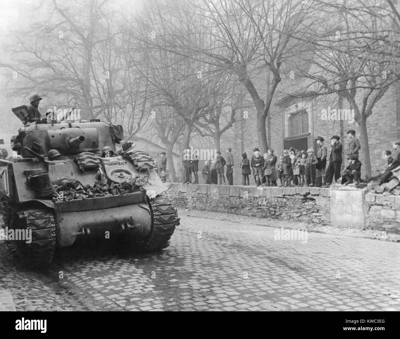 German children watch U.S. Tanks of 87th Division, Third U.S. Army, enter town of Kobern, Germany. March 16, 1945. Kobern, was on the Moselle River five miles southwest of Coblenz. World War 2 (BSLOC 2015 13 70) Stock Photo