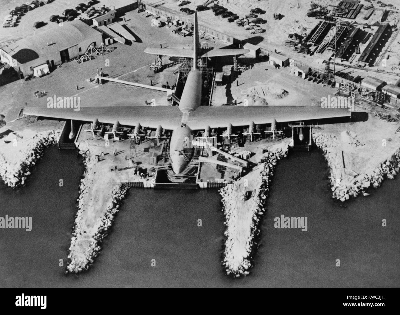 Aerial view of Hughes Flying-boat seaplane under construction at its dock in Long Beach, 1947. The prototype was named 'Hughes H-4 Hercules', but better known as the 'Spruce Goose' because of its wood (birch) construction. Developed as a troop transport, it was six times larger than any aircraft of its time. On Nov. 2, 1947 it made its only test flight, because the war that caused its creation was over. (BSLOC 2015 14 123) Stock Photo