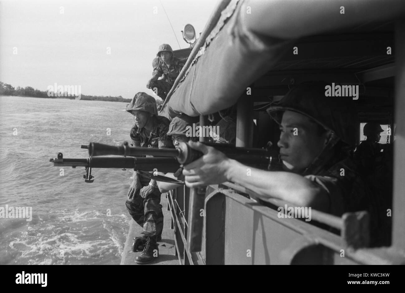 Vietnamese soldiers inspecting the shoreline from inside a boat to prepare for landing. Feb. 15, 1962. Photo by Robert Pepper Martin. (BSLOC 2015 14 134) Stock Photo