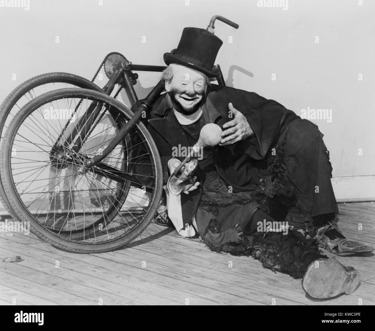 Hobo clown Joe Jackson reclining against a disassembled bicycle at the New York World's Fair in 1940. His pantomime act incorporated comic stunt bicycling and was taken over by his son, Joe Jackson Jr. (BSLOC 2015 14 162) Stock Photo