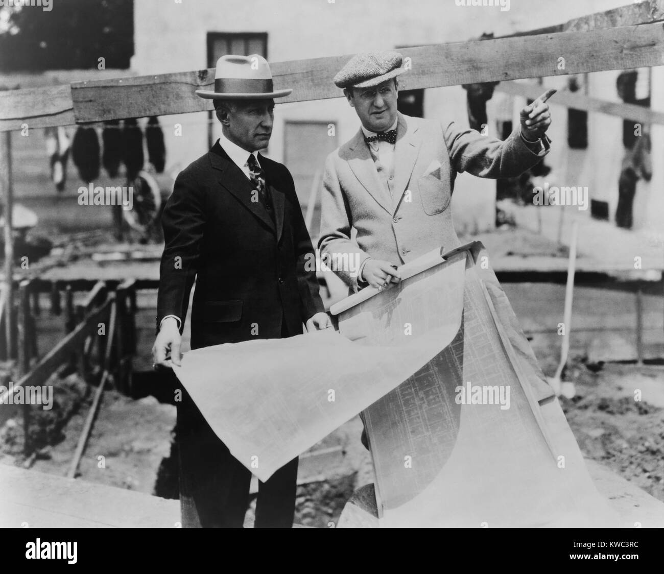 Adolph Zukor (left) and Jesse Lasky at a construction site holding blueprints. The founders of Paramount Studios were likely building in their Hollywood studio complex in the late 1910s. (BSLOC 2015 14 175) Stock Photo