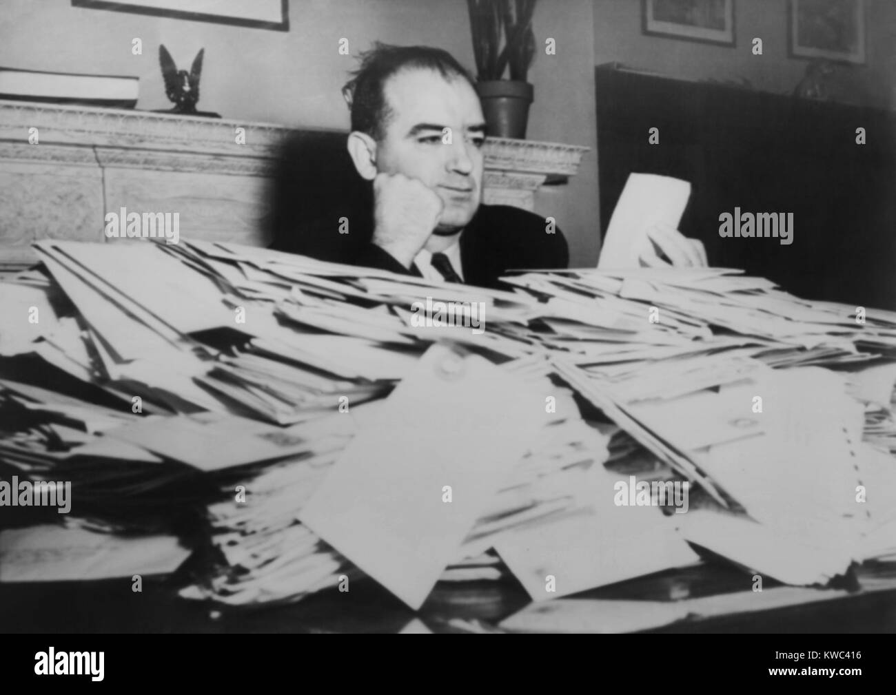Sen. Joseph R. McCarthy sits at desk piled high with mail, March 24, 1950. He received over 5000 letters a day. Elected Republican Senator from Wisconsin in 1947, he became foremost provocateur of the 1950s 'Red Scare' in America. (BSLOC 2015 14 24) Stock Photo