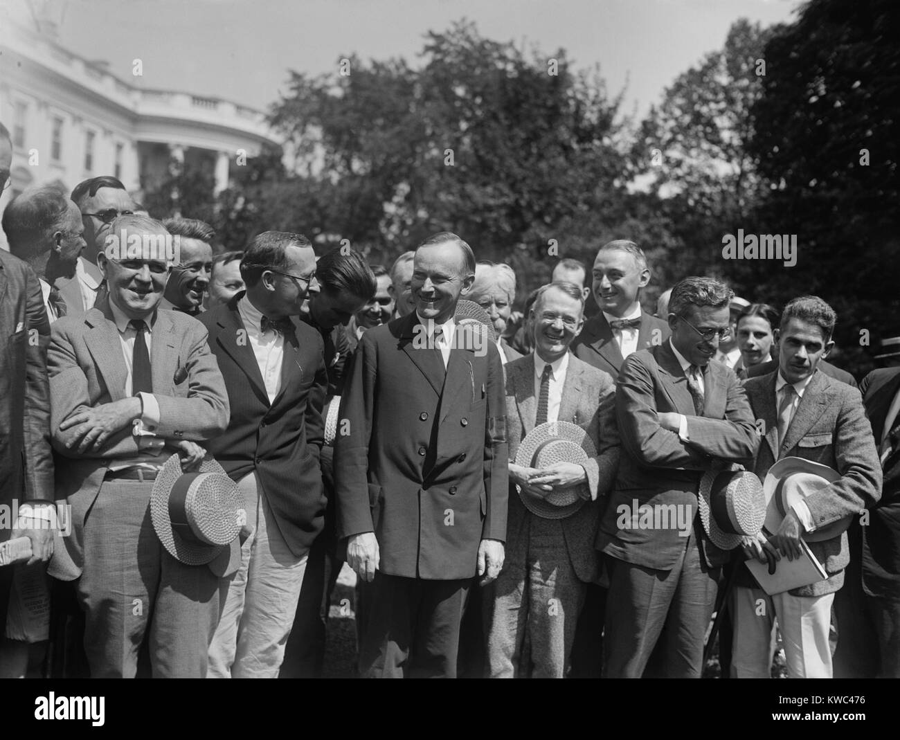 President Calvin Coolidge talking with Newspapermen at the White House, Aug. 14, 1923. Coolidge is wearing a mourning band on his sleeve for the late President Warren Harding who died less than two weeks earlier. (BSLOC 2015 15 115) Stock Photo