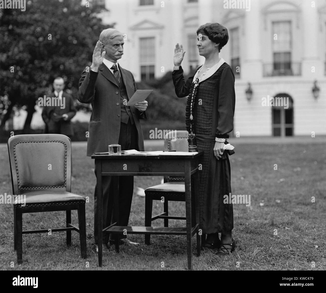 First Lady Grace Coolidge taking an oath before filling out her ballot for the 1924 Election. President Calvin Coolidge stands in the background. (BSLOC 2015 15 117) Stock Photo