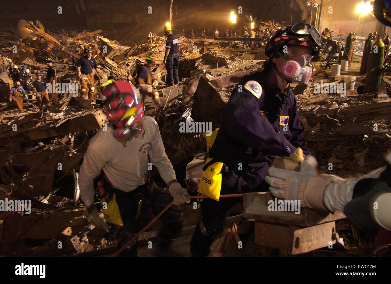 Workers lift rubble and search for survivors. Rescue operations continued into the night at the Ground Zero 7 days after the 9-11 attack on NYC, Sept. 19, 2001. World Trade Center, New York City, after September 11, 2001 terrorist attacks. (BSLOC 2015 2 101) Stock Photo