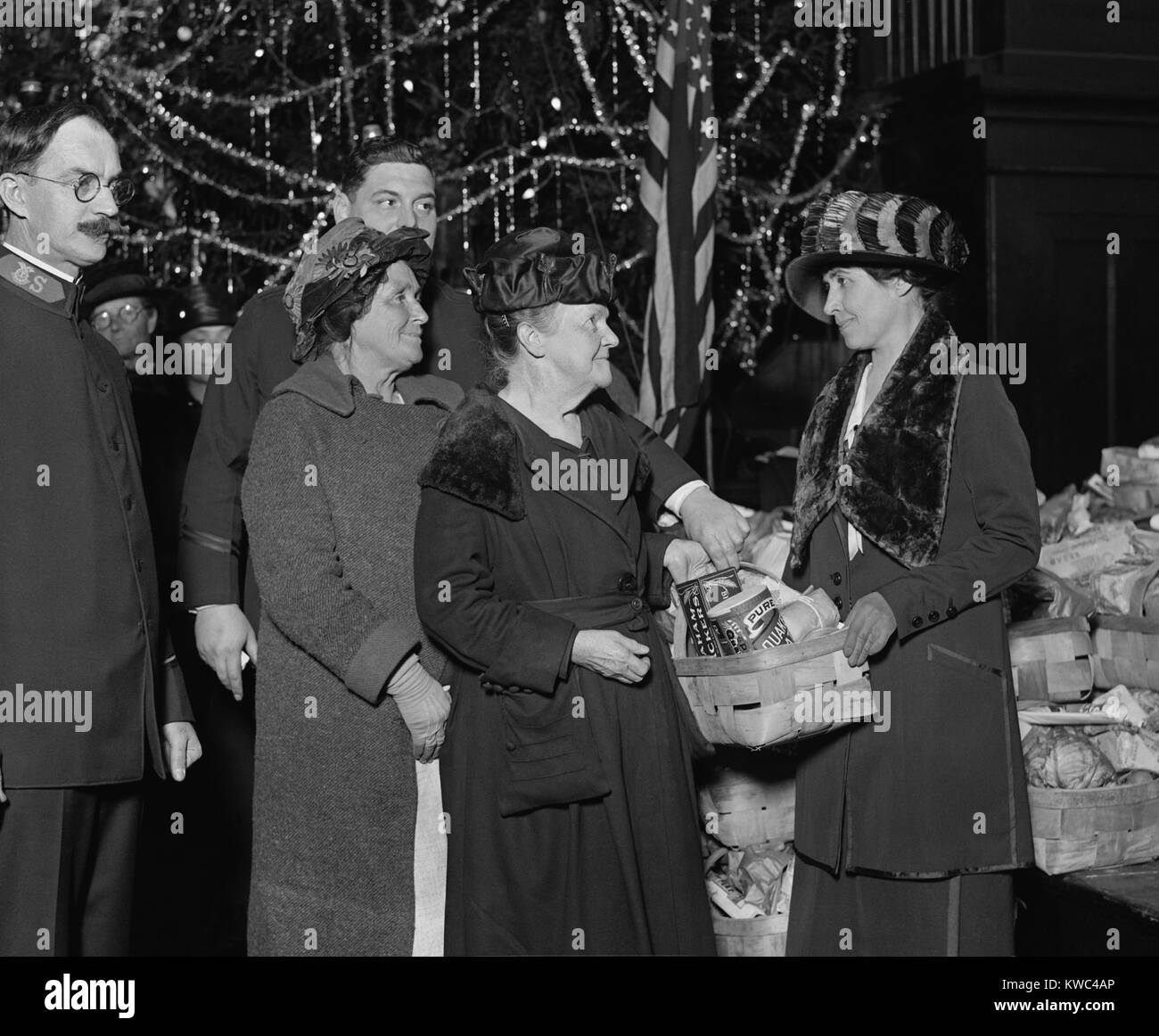 First Lady Grace Coolidge with Salvation Army Group, Dec. 24, 1923. She holds a food basket containing Quaker Oats and Graham Crackers and other staples. (BSLOC 2015 15 154) Stock Photo