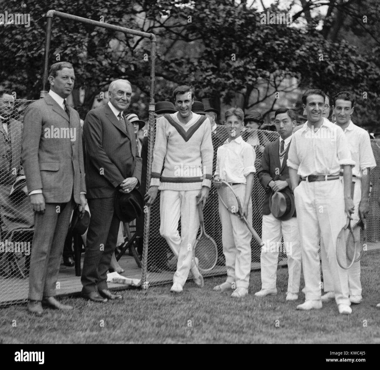President Warren Harding stands next to tennis champion Bill Tilden, May 11, 1923. Second from right is Spanish Tennis player Manuel Alonso. White House Tennis Court. (BSLOC 2015 15 51) Stock Photo