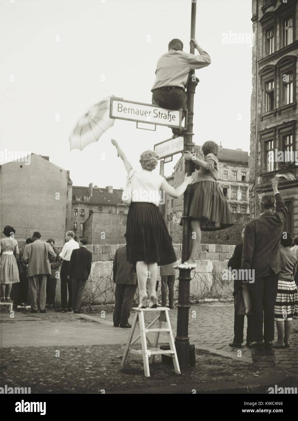 West Berliners in the French sector waved to friends and relatives in East Berlin. At Bernauer Strasse they used small ladders, lampposts, and bricks to get a better view across the Berlin Wall. Eventually the East German 'VOPOS' (People's Police) tossed tear gas grenades over the border barrier to break up the gathering. Sept. 13, 1961. (BSLOC 2015 2 264) Stock Photo
