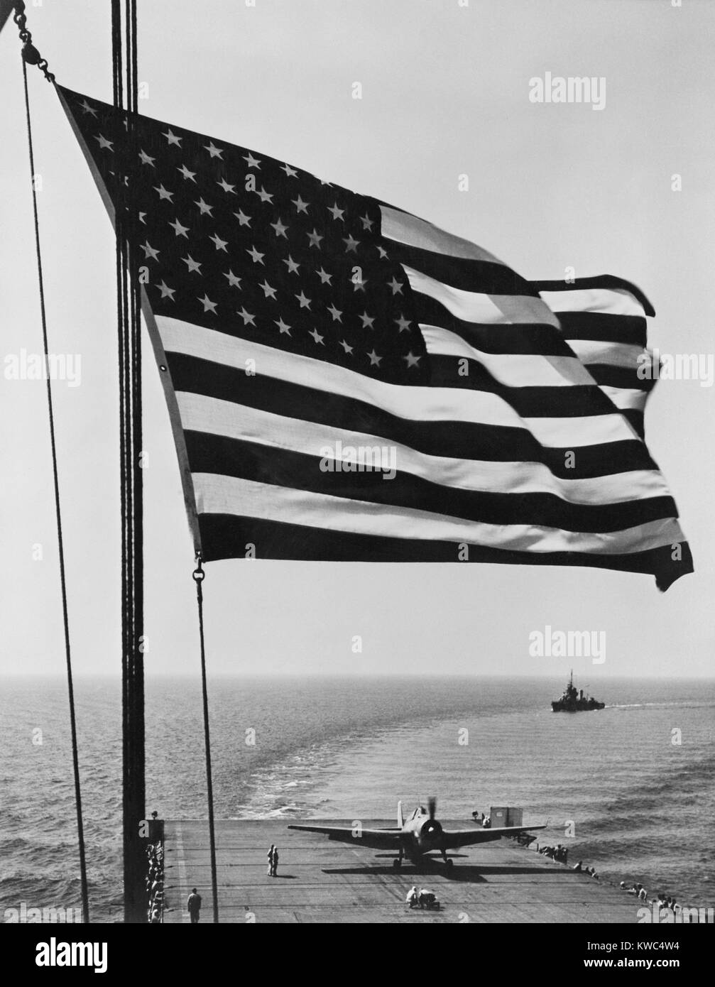 Flag of the United States snaps in the breeze over the USS Santee. November 1942. USS Santee was one of 4 escort carriers in Operation Torch, the Nov. 1942 Allied invasion of North Africa. Photo by Horace Bristol, member of the U.S. Naval Aviation Photographic Unit, under the command of Capt. Edward Steichen. World War 2. (BSLOC 2015 13 119) Stock Photo