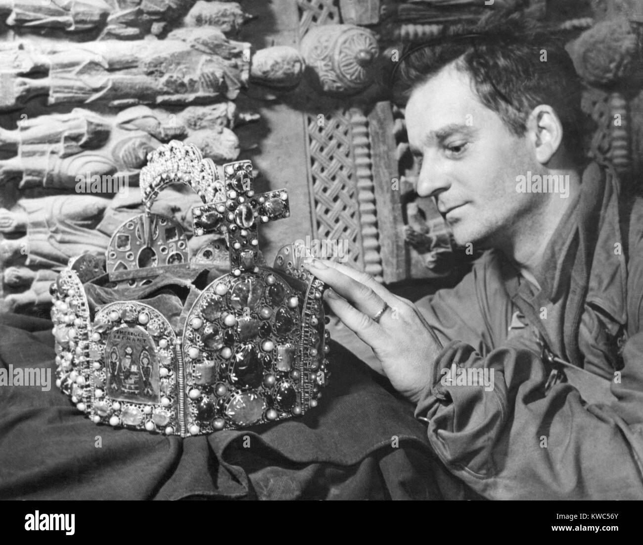 U.S. Soldier with 'Crown of Charlemagne' in a cave in Siegen, Germany. It was among many looted art treasures hidden there and in hundreds of other sites across Germany. U.S. Army Monuments, Fine Arts, and Archives (MFA&A) Section was responsible of the artwork's care and restitution. World War 2 (BSLOC 2015 13 96) Stock Photo