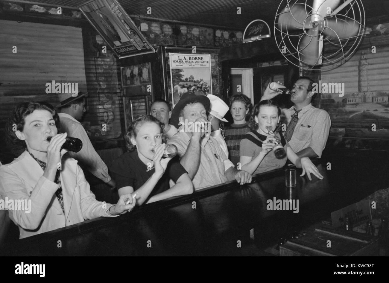 Men and women drinking beer in a bar on crab boil night, in Raceland, Louisiana. Sept. 1938 photo by Russell Lee. (BSLOC 2015 14 140) Stock Photo