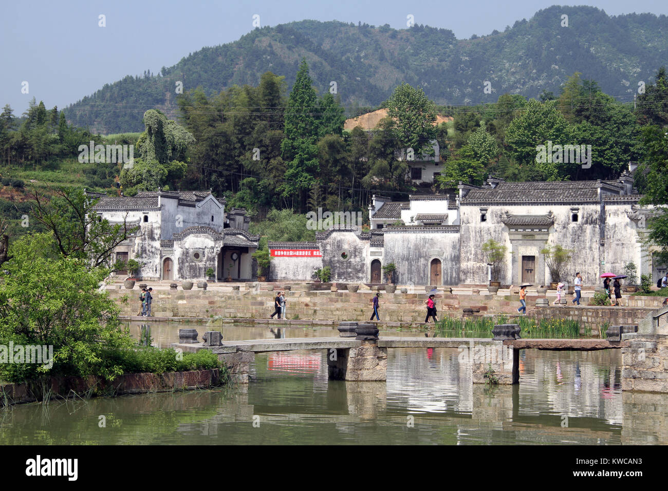People near lake with buildings in Shexian town, China Stock Photo