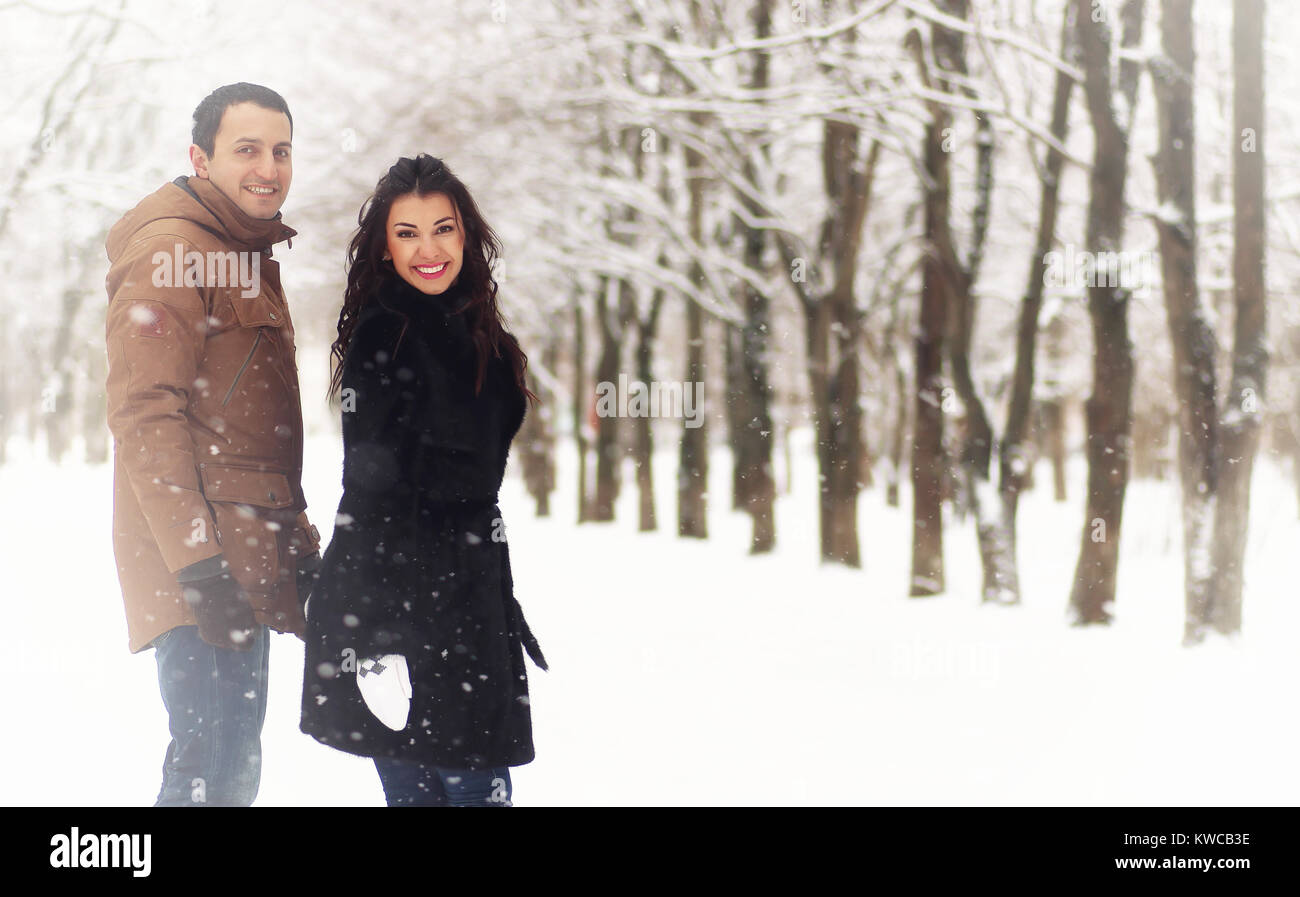 A young loving couple on a walk in a snow park Stock Photo - Alamy