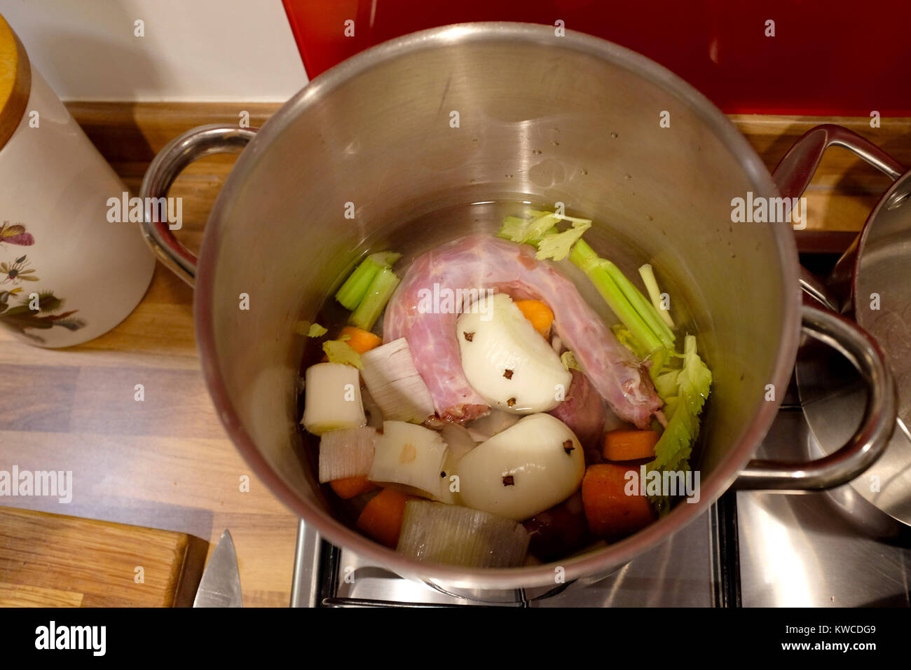 Turkey stock made from giblets and vegetables including onion carrot and celery simmering on gas hob in pot Stock Photo