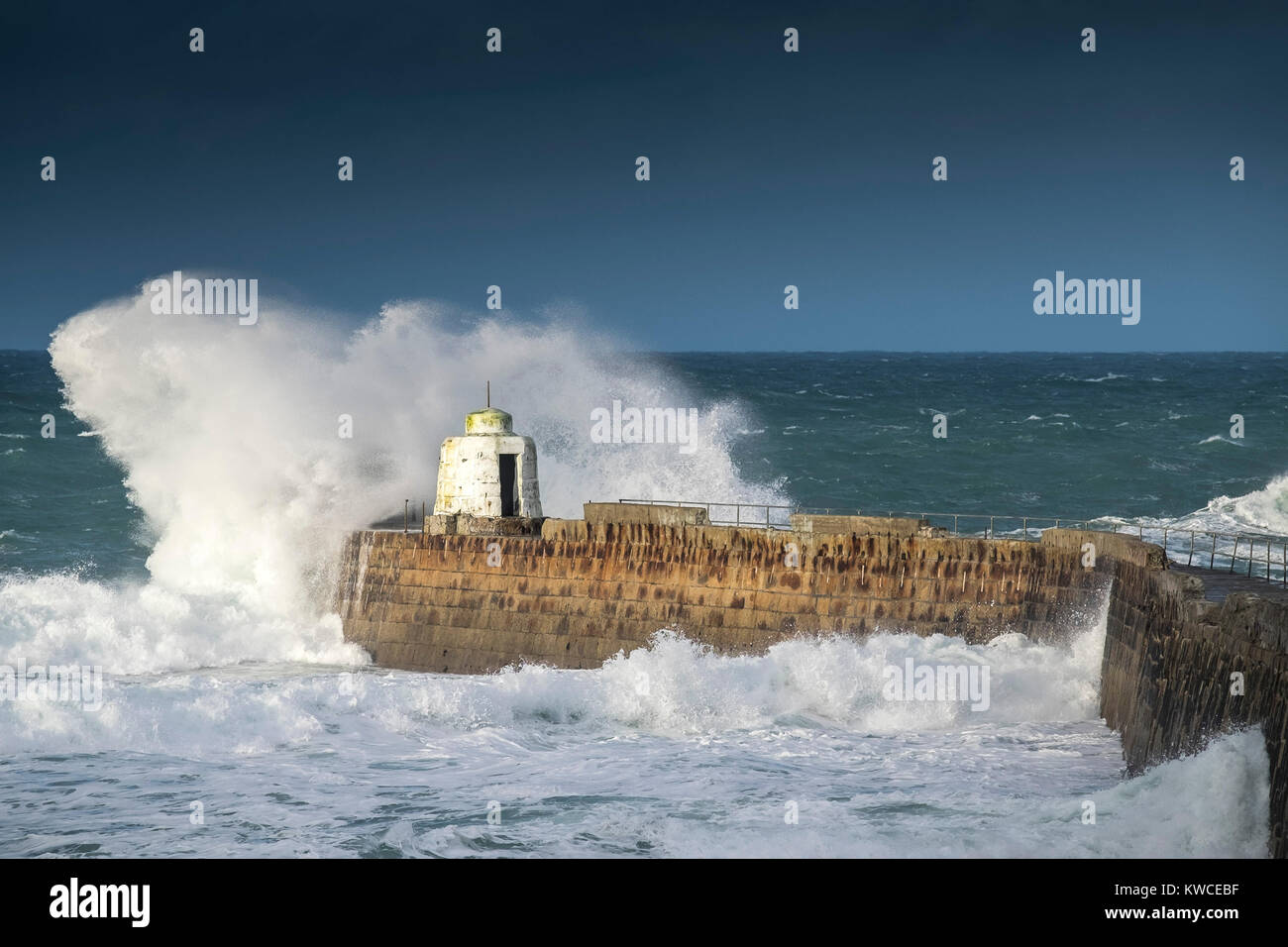 UK weather - Gale force winds driving huge waves into the pier at Portreath Harbour in Cornwall. Stock Photo