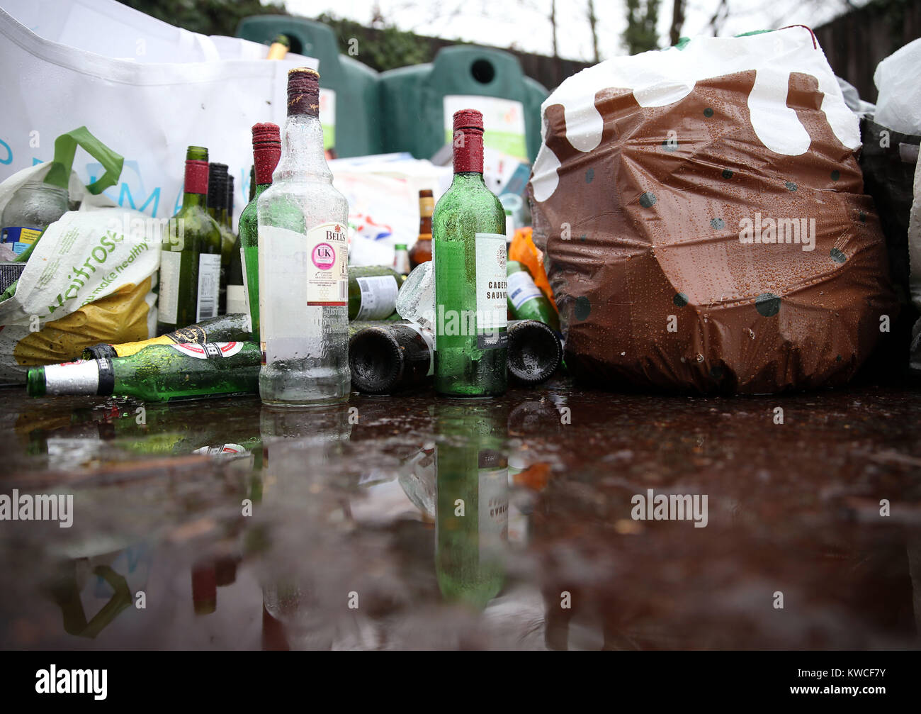 Empty bottles dumped in front of glass recycling bins at a centre near