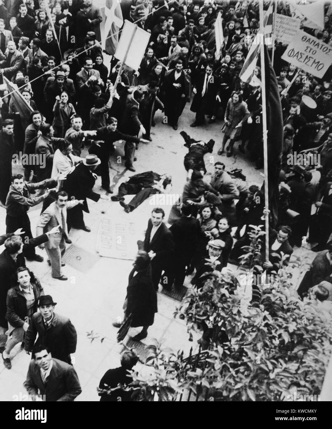 Crowd shouting and pointing towards a dead man and a woman lying in an Athens street. After liberation from the Germans, Greek politics between Leftists and Communists against the Rightists and Royalists became violent. Dec. 18, 1944. - (BSLOC 2014 15 220) Stock Photo