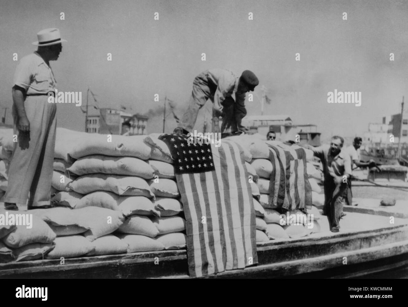 Sacks of flour, the first relief supplies from the United States, being unloaded in the port of Piraeus. American and Greek flags are displayed. 1947. The U.S. economic aid to the Rightist-Royalist side of the Greek Civil War became the model for the Marshall Plan. - (BSLOC 2014 15 226) Stock Photo